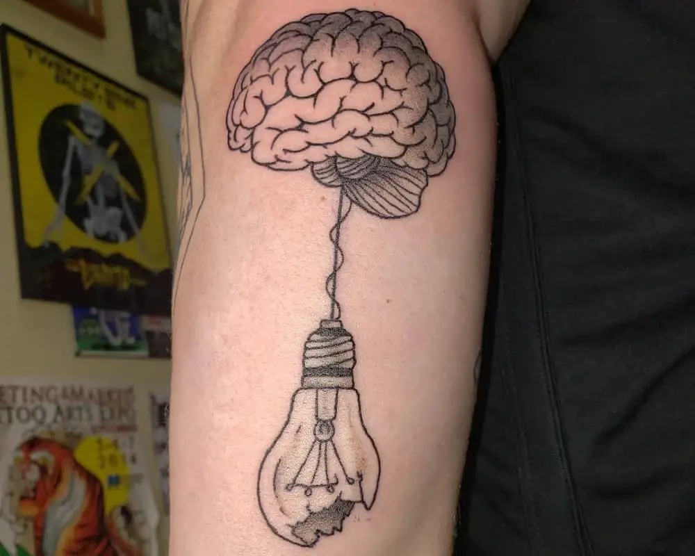 Brain tattoo with a broken light bulb hanging from it