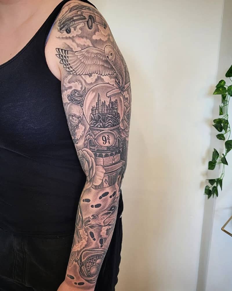 Full arm tattoo depicting an owl with a letter, Hogwarts, footprints in the Marauder's Map and other details