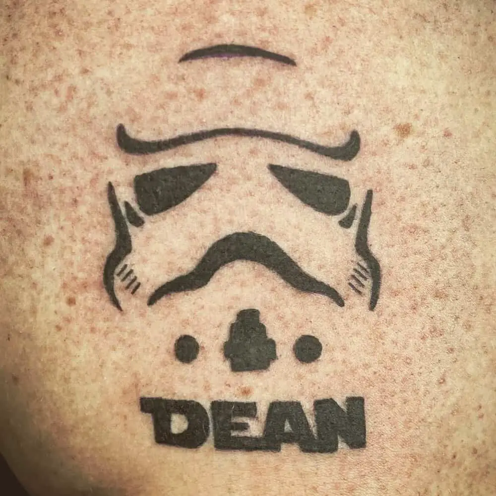 Tattoo in the shape of an imperial helmet and the inscription dean
