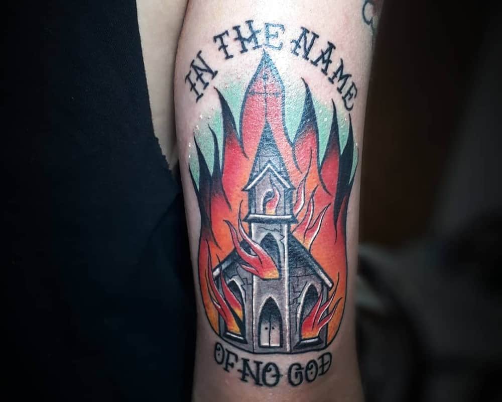 Tattoo of a burning church and the inscription in the name of no god
