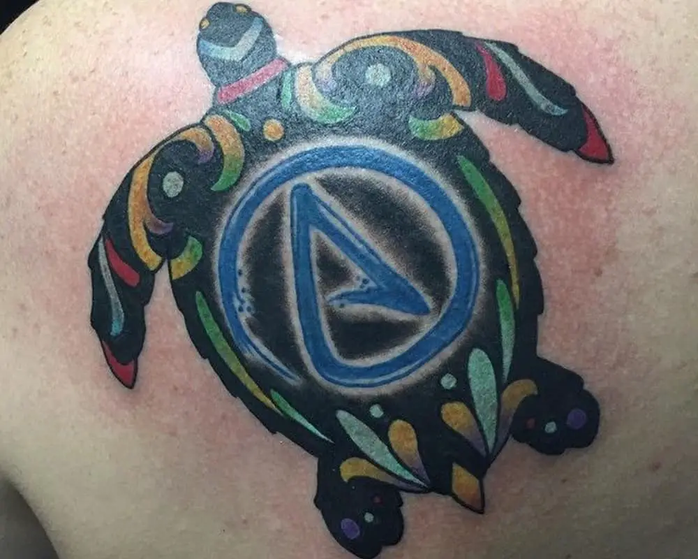 Tattoo of a turtle with the symbol A on its shell