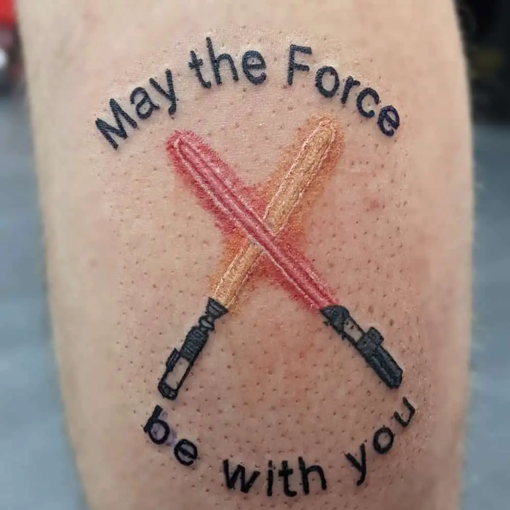 Tattoo of crossed lightsabers and the inscription May the forse be with you