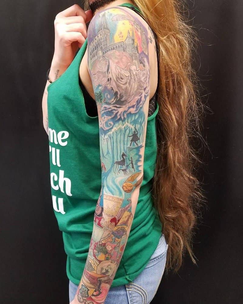 a very colourful full arm tattoo with scenery from Harry Potter