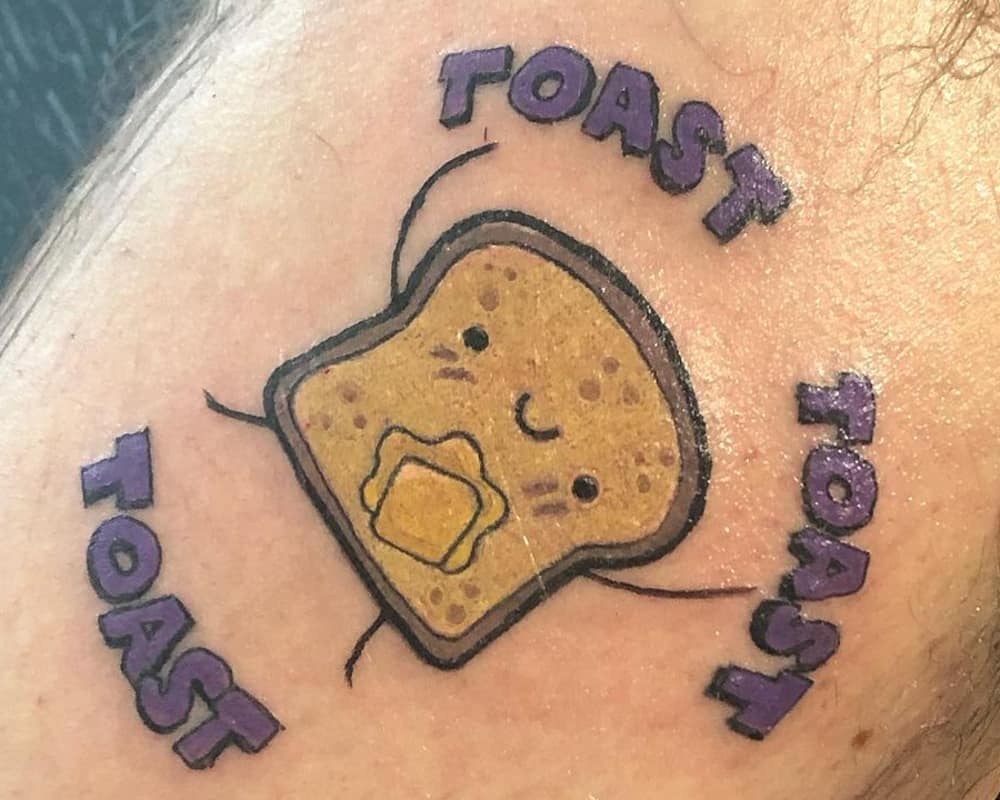 tattoo of a cute buttered toast with the words "toast toast toast"