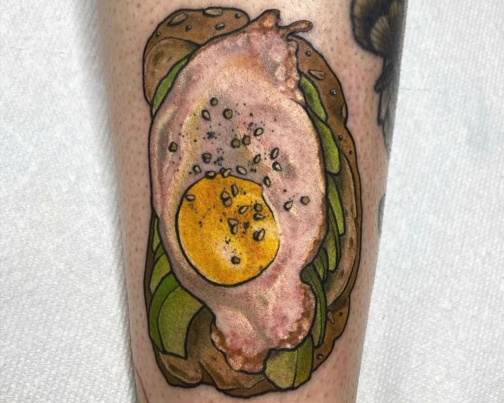 tattoo of a realistic avocado toast and scrambled eggs