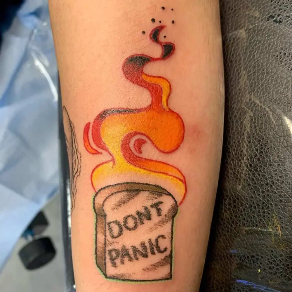 tattoo with burning toast and write dont panic