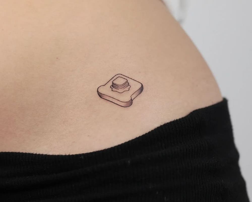 tiny butter toast tattoo on the hip