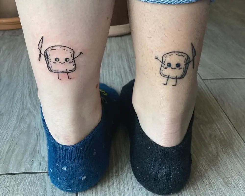 two tattoos of cute toasts with knives in their hands on their ankles