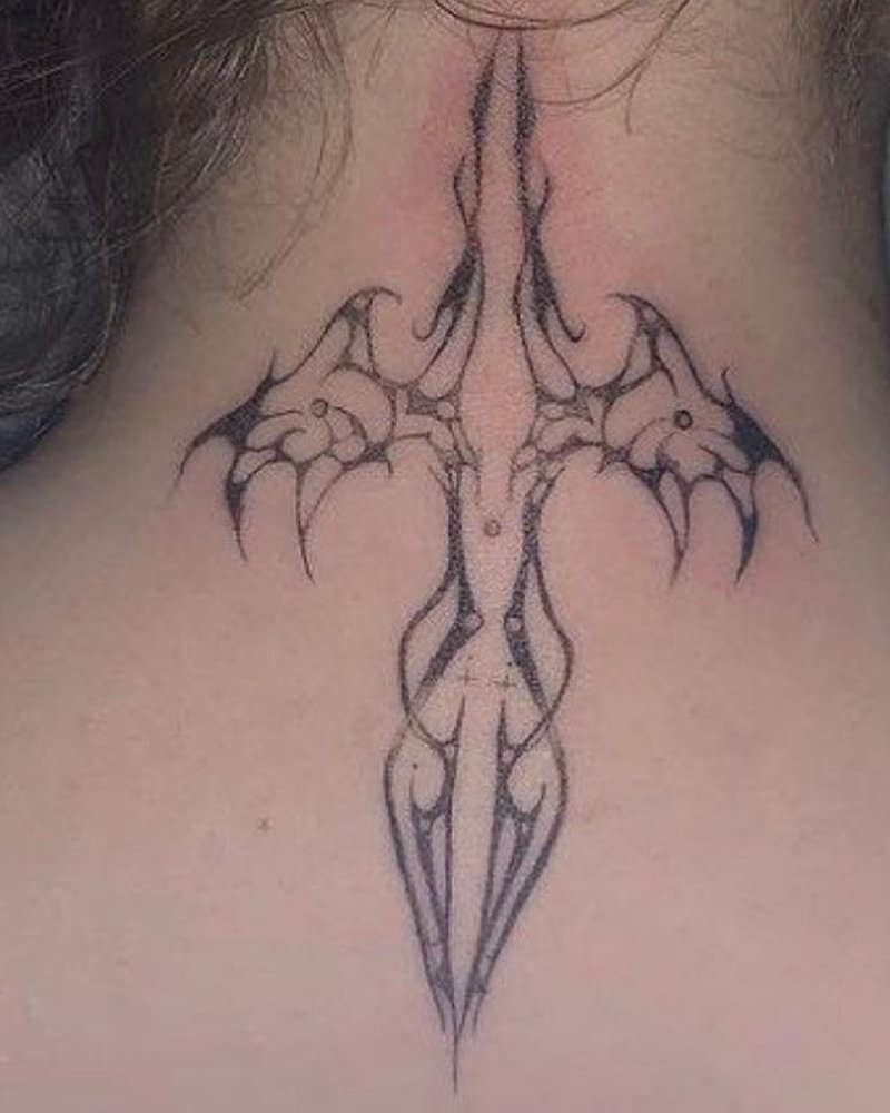 A black tattoo resembling a bird or cross