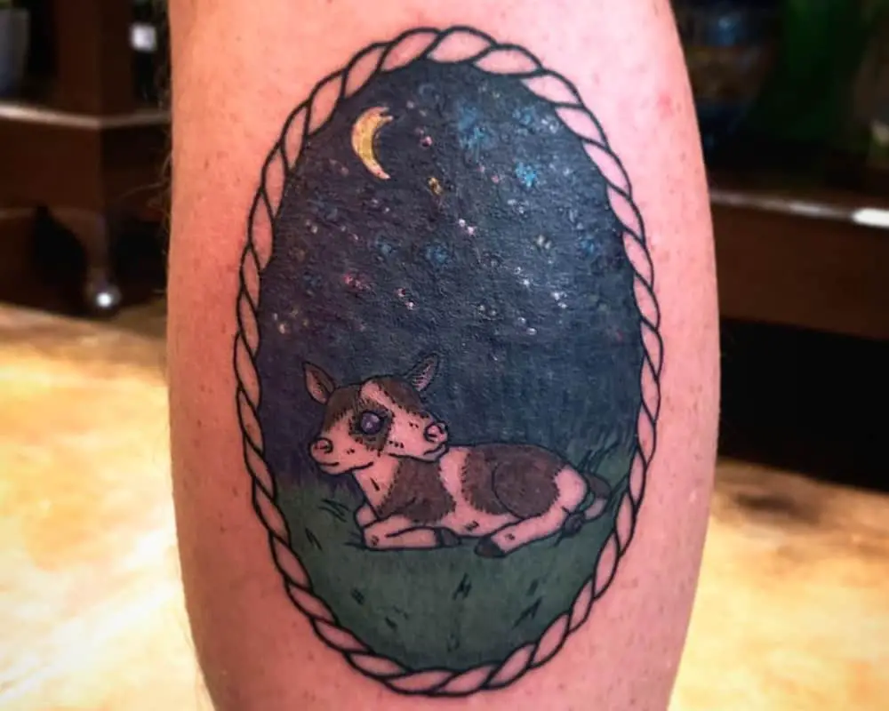 A coloured tattoo of a lying two-headed calf in a night meadow