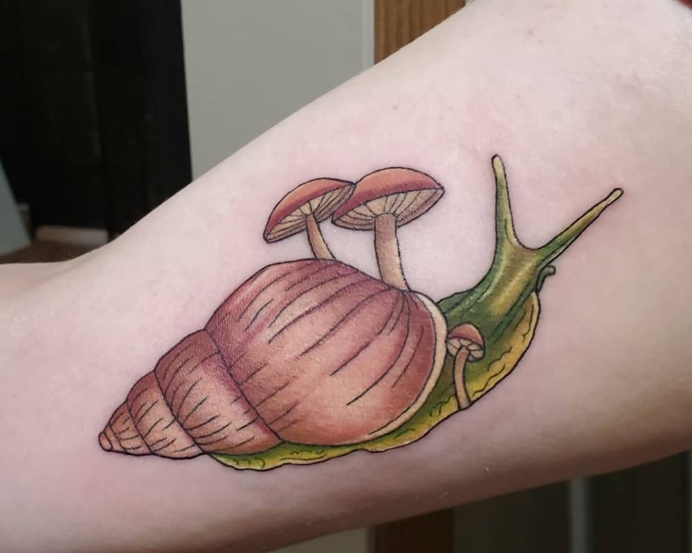 A snail tattoo with mushrooms growing on it