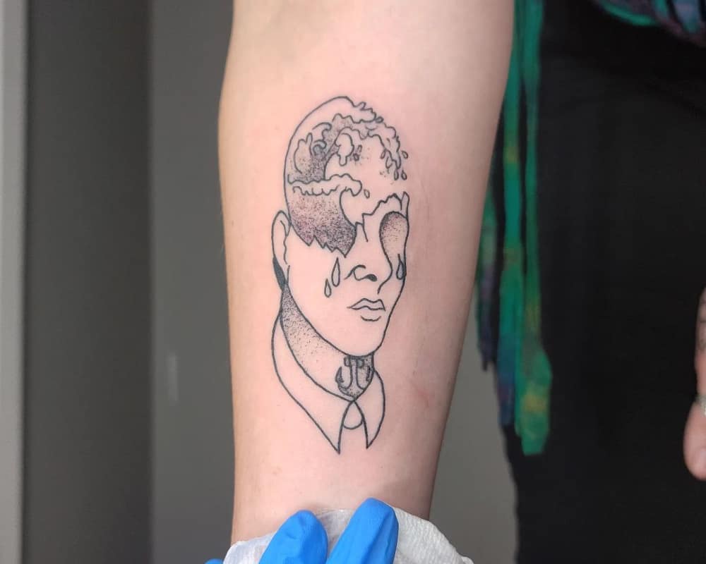 A tattoo in the form of a broken head with waves inside