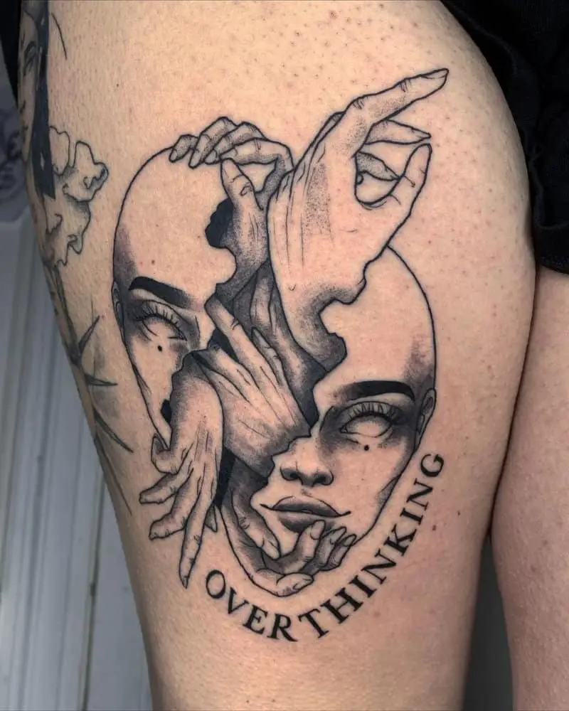 A tattoo in the form of a split head and arms coming out of it