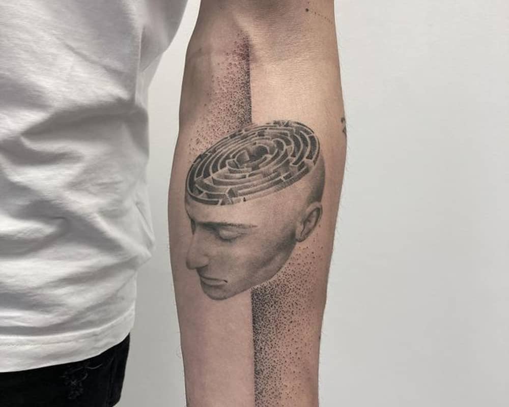 A tattoo in the shape of a head with a labyrinth inside