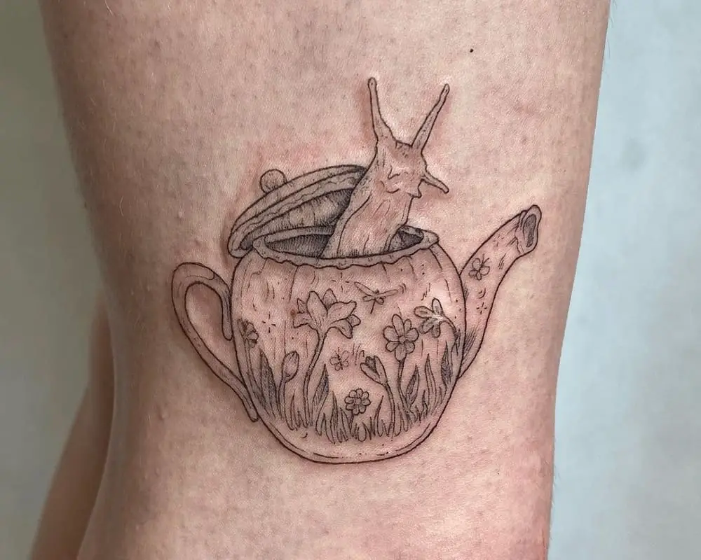 A tattoo in the shape of a teapot with a snail peeking out of it