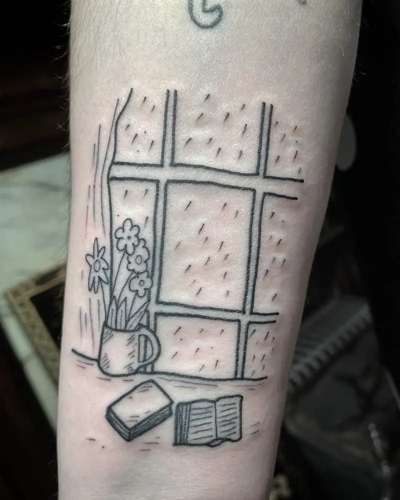 A tattoo in the shape of a window behind which it is raining