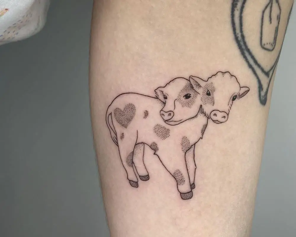 A tattoo of a cute spotted two-headed calf with a heart