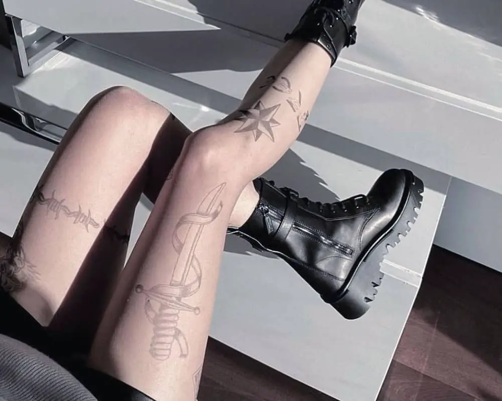 A tattoo of a dagger and star on one leg and barbed wire on the other