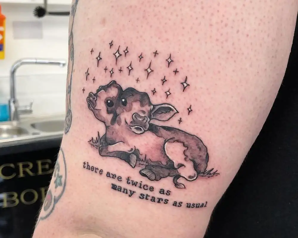 A tattoo of a lying two-headed calf under the stars and the inscription there are twice as many stars as usual