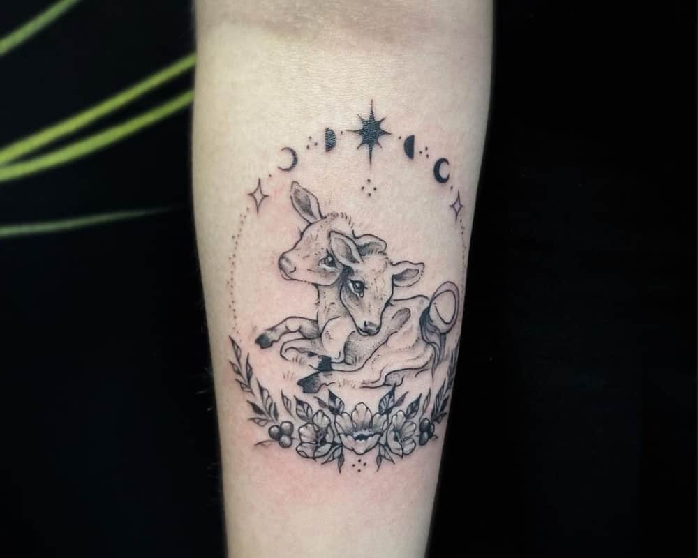 A tattoo of a recumbent two-headed calf in a circle of flowers and stars