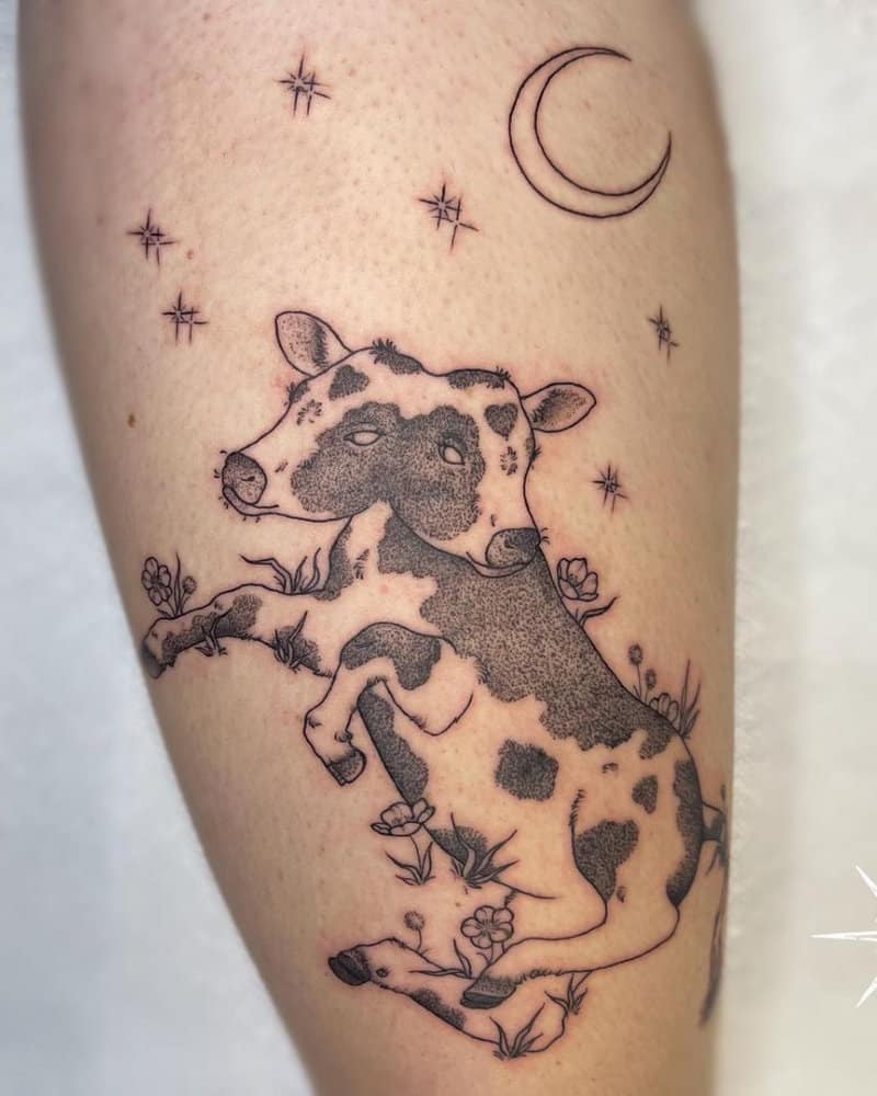 A tattoo of a spotted two-headed calf under the moon in a flowery meadow