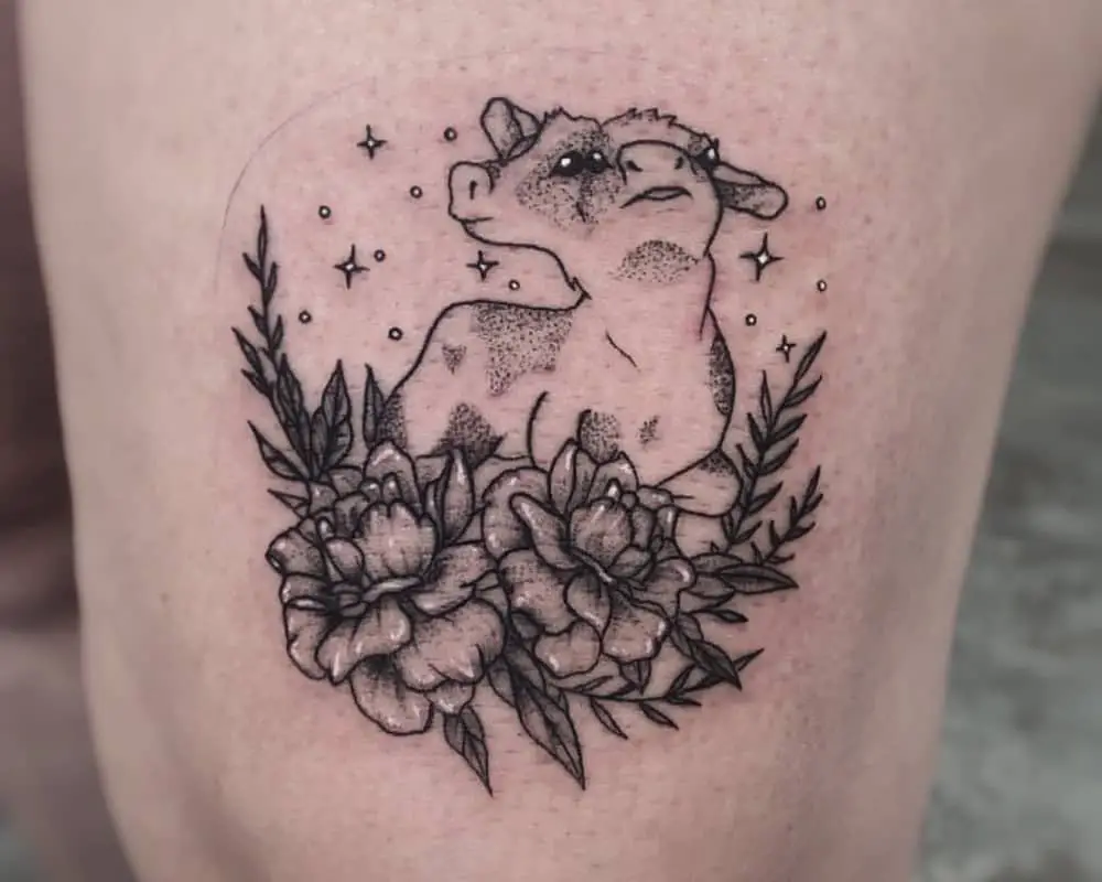 A tattoo of a two-headed calf lying in flowers, looking up at the stars