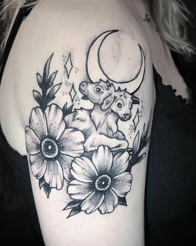 A tattoo of a two-headed calf with flowers and the moon in the background