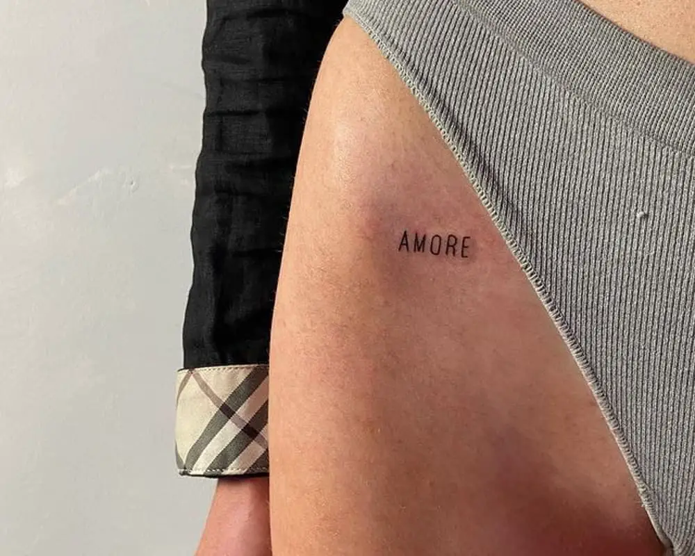 A tiny tattoo inscription Amore