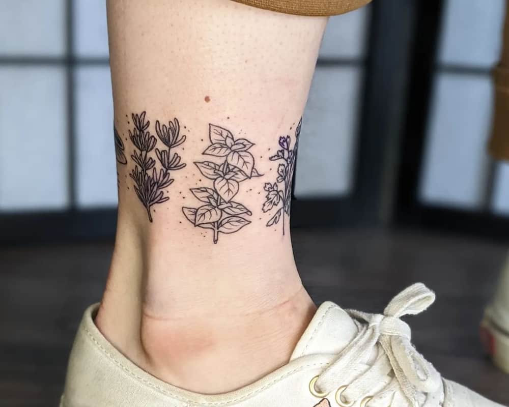 An ankle tattoo in the shape of branches of a plant