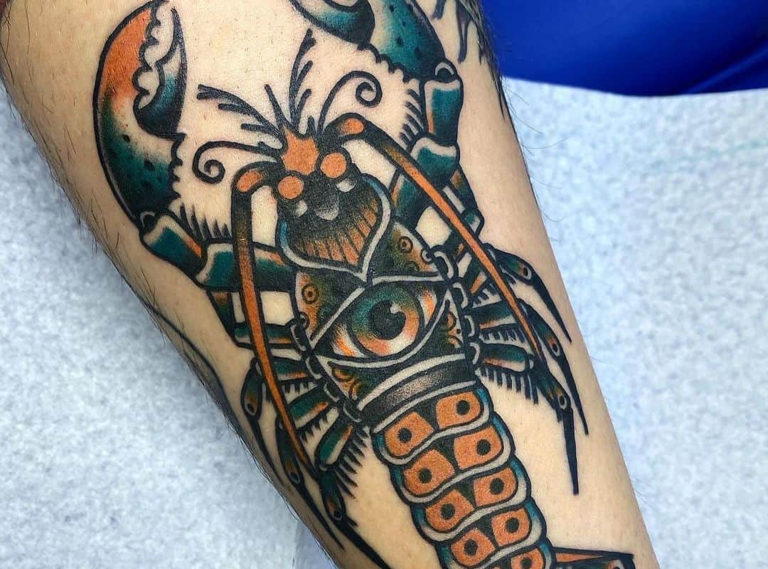 Black&orange lobster with eye in the centre tattoo