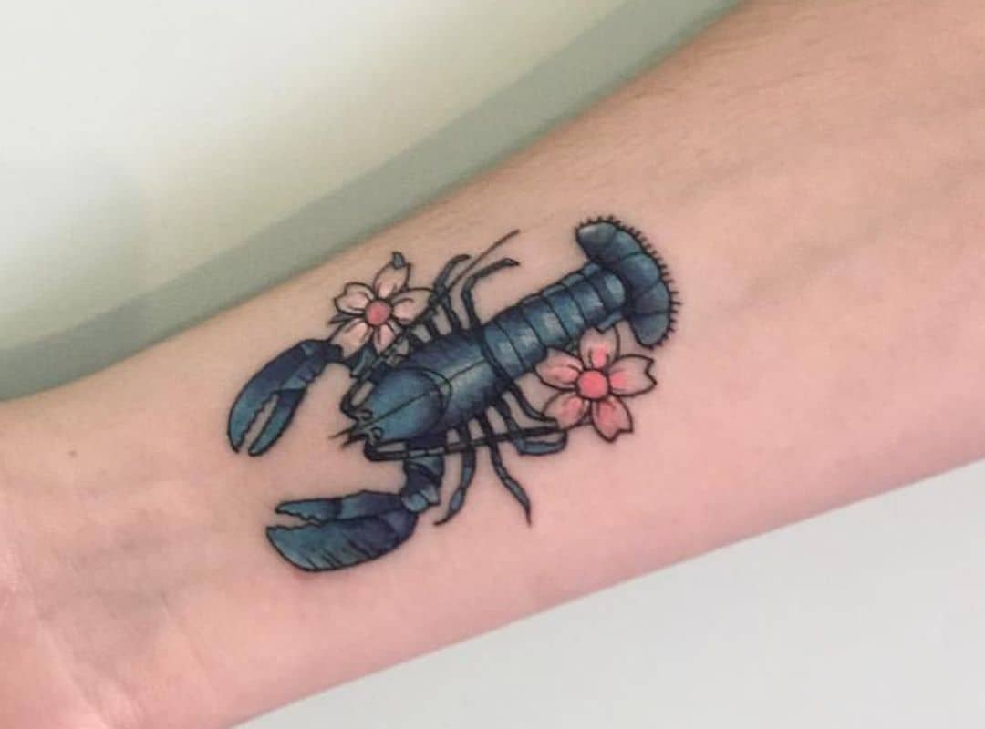 Blue lobster with flowers around wrist tattoo
