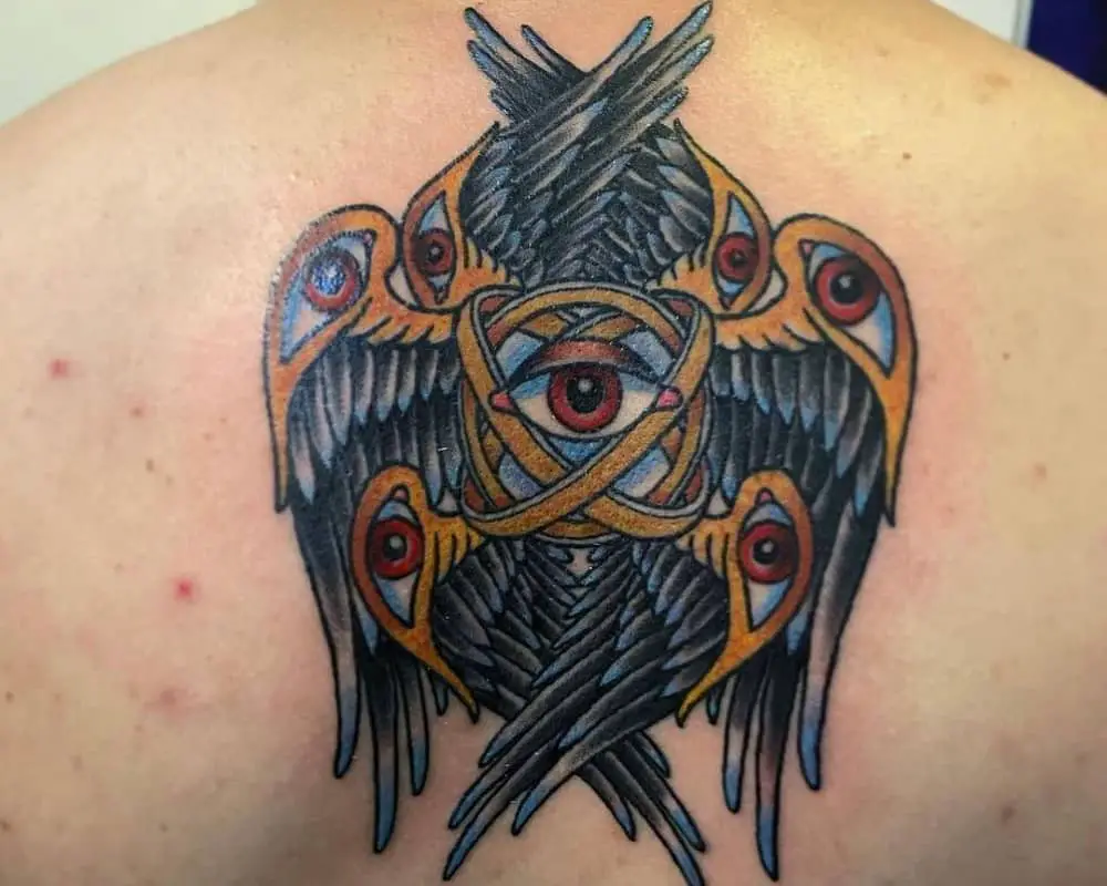 Colourful tattoo of an angel with rings of seven eyes and six wings