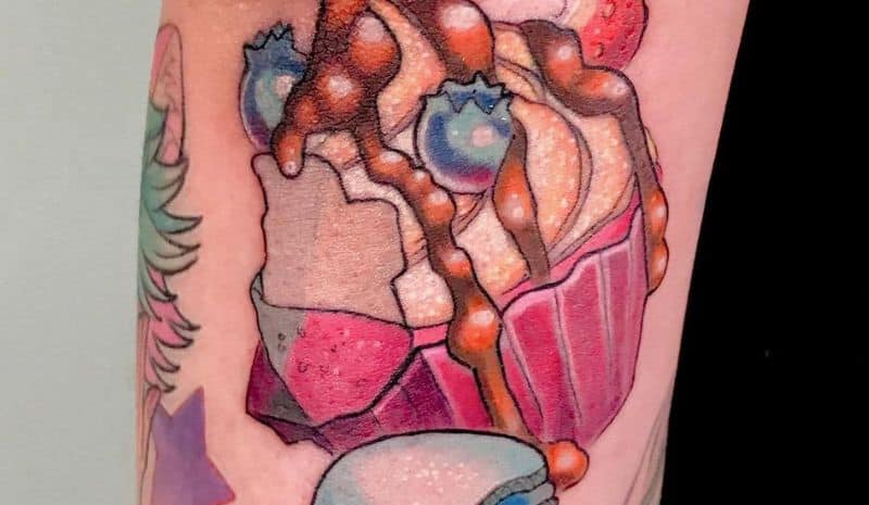 Cupcake with topping and berriesand macaroons tattoo