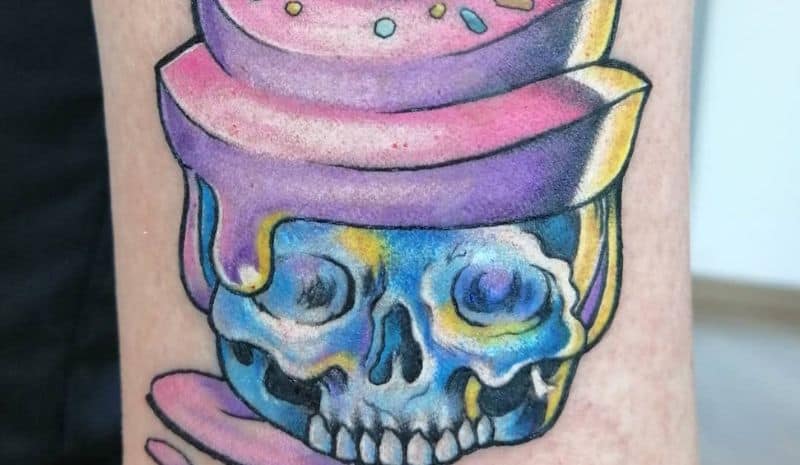Pink cupcake in blue skull tattoo