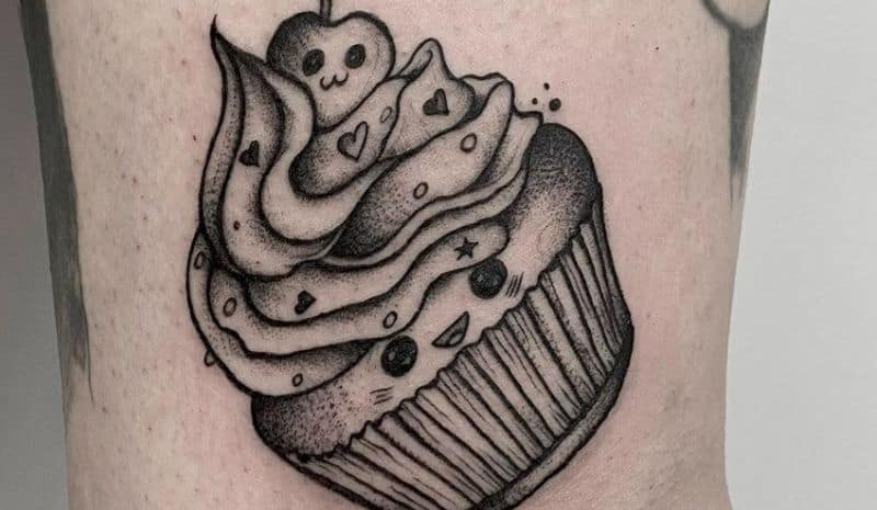 Cupcake with berry and face tattoo