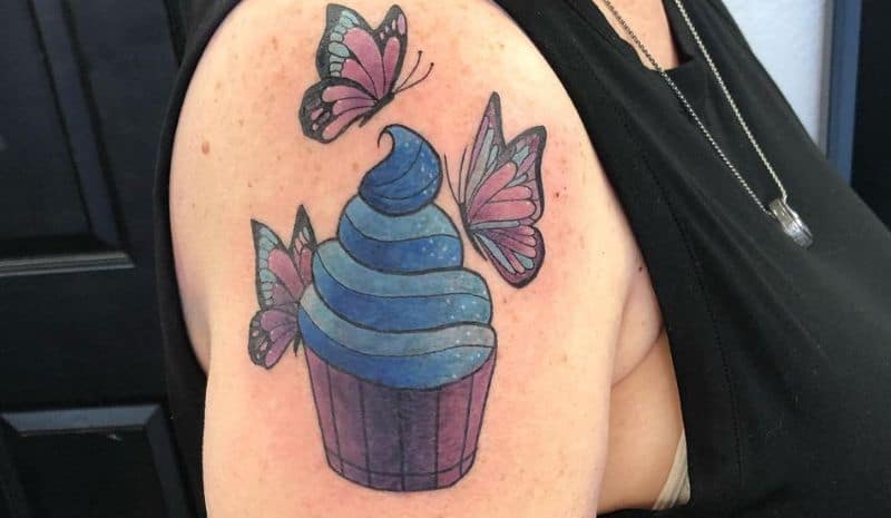 Cupcake with blue cream and butterflies around tattoo
