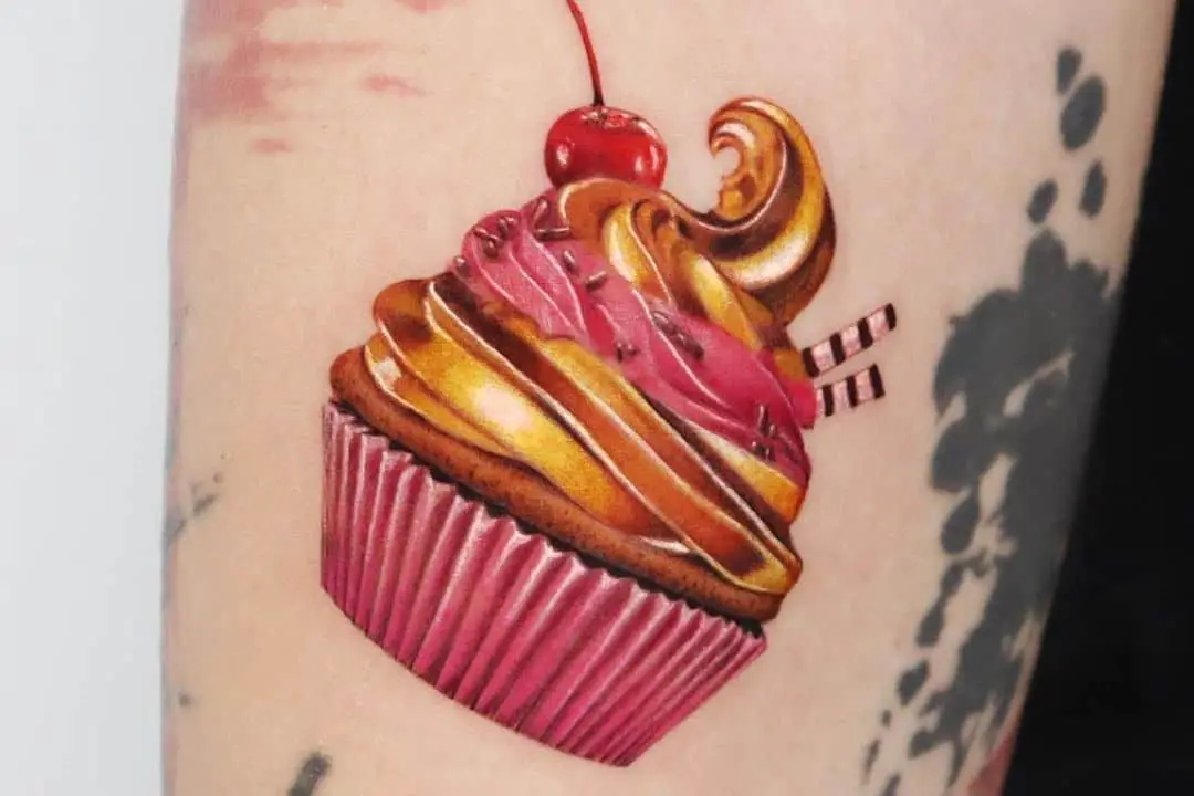Golden and pink cupcake tattoo with a cherry tattoo