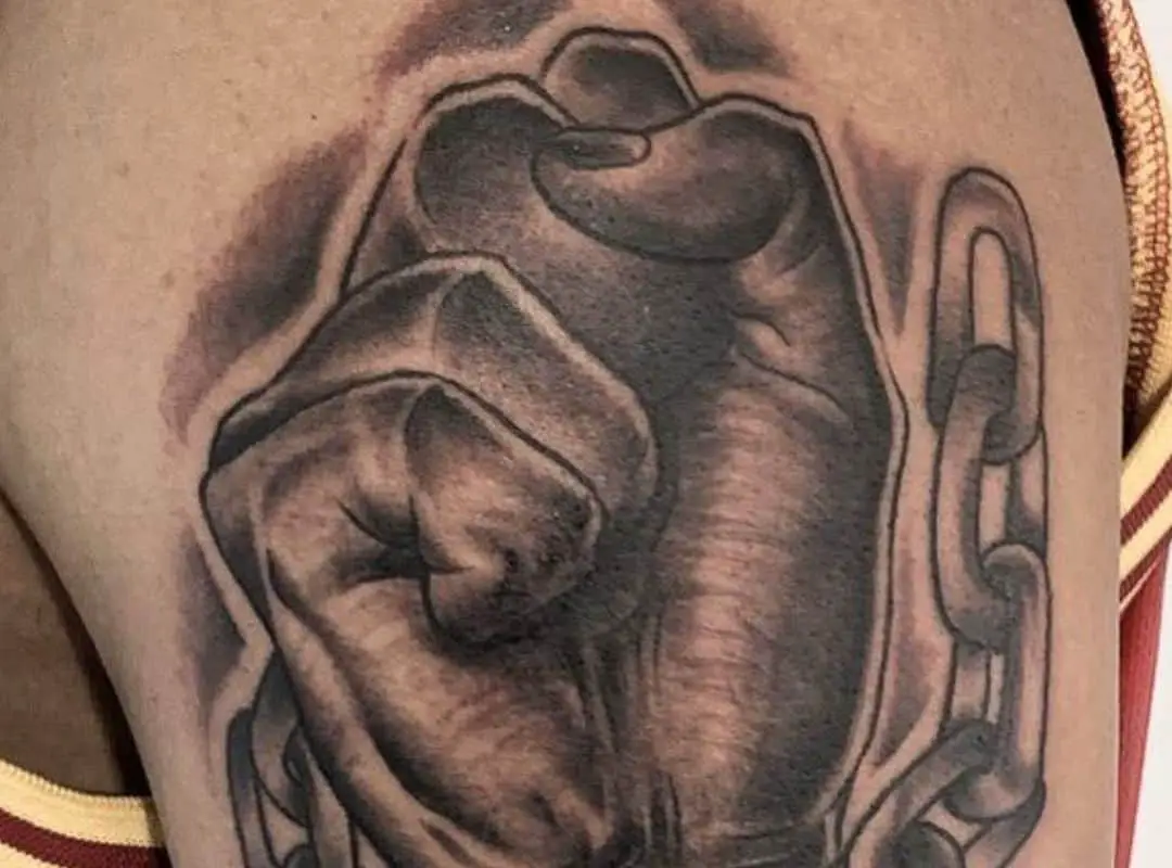 Hand breaking chain tattoo