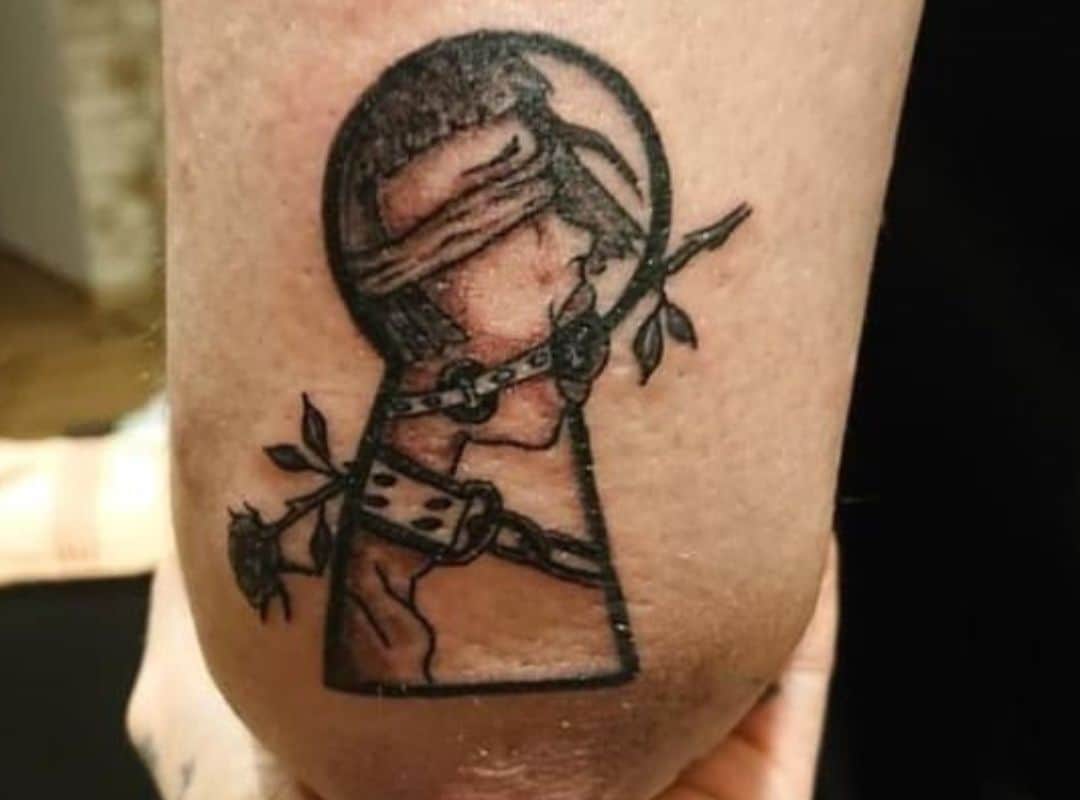 Key hole with BDSM woman in the centre tattoo