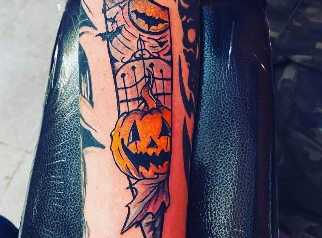 Image of gate, bats and pumpkin on the knife tattoo