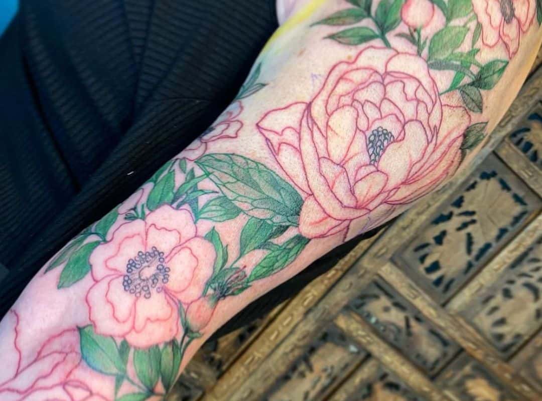 Pink flowers and green leaves tattoo