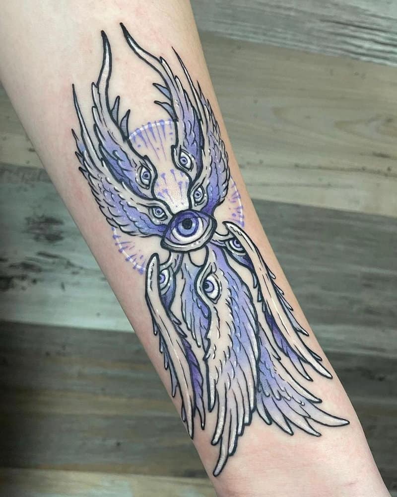 Purple tattoo showing four pairs of wings with eyes and one eye in the centre