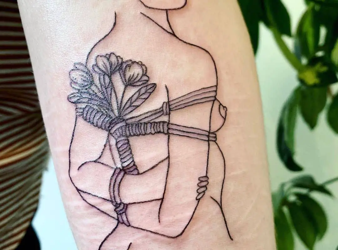 Silhouette with tied flowers tattoo