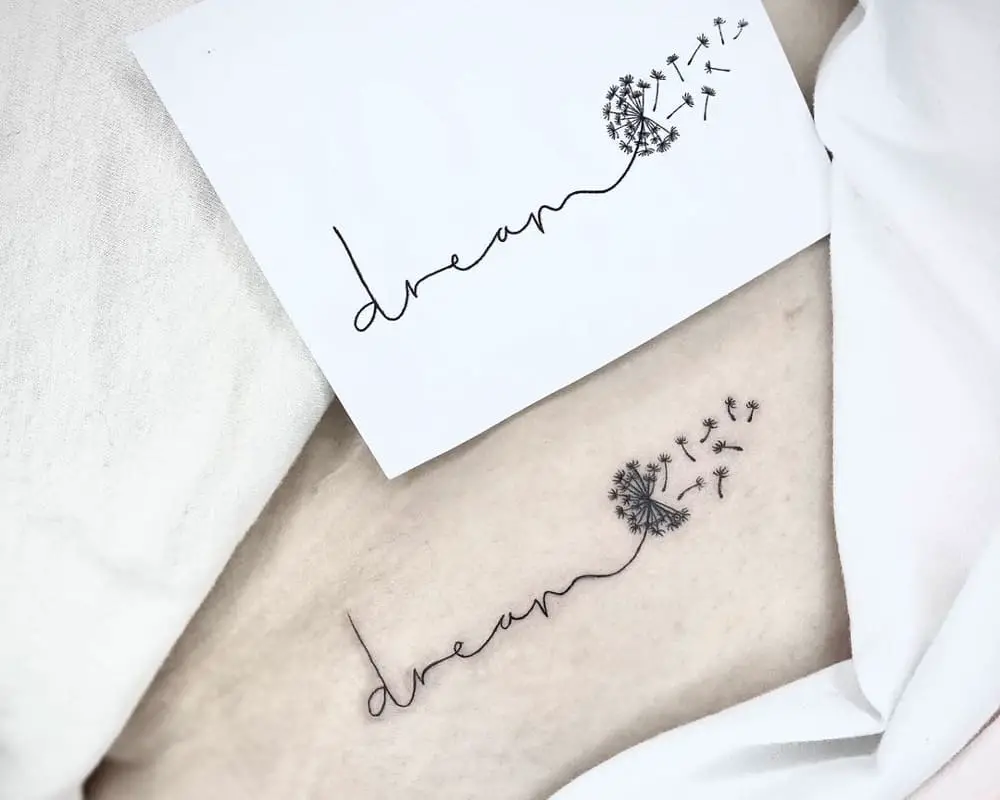 Tattoo a gentle inscription on the end in the form of a dandelion