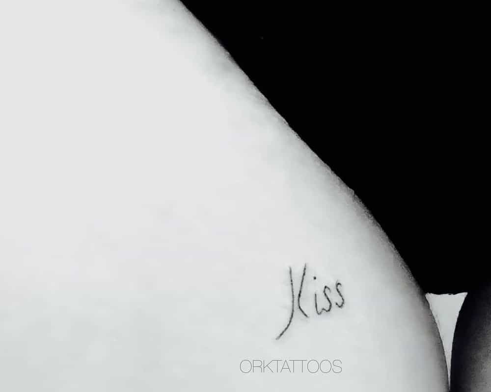 Tattoo a tiny inscription kiss