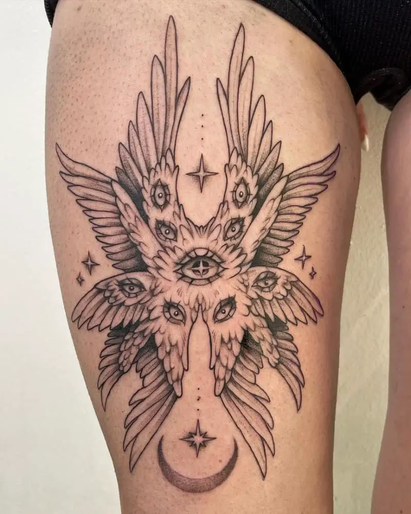Tattoo in the form of four pairs of wings with eyes and stars with the moon on the thigh