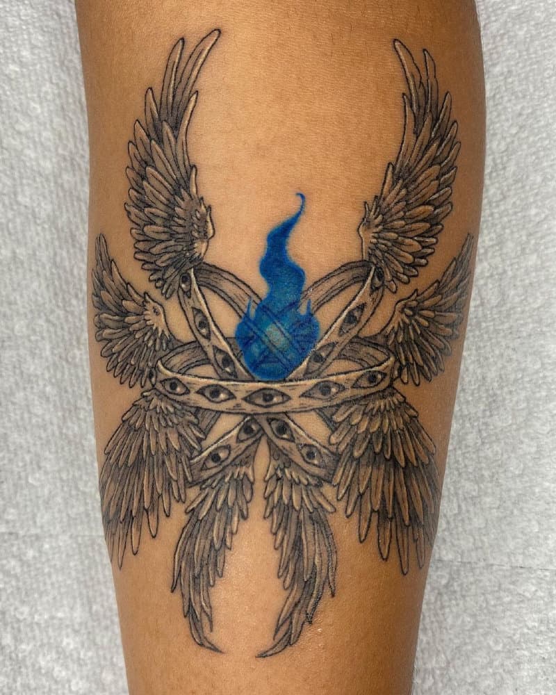 Tattoo in the form of three rings with eyes and eight wings and a blue fire in the center