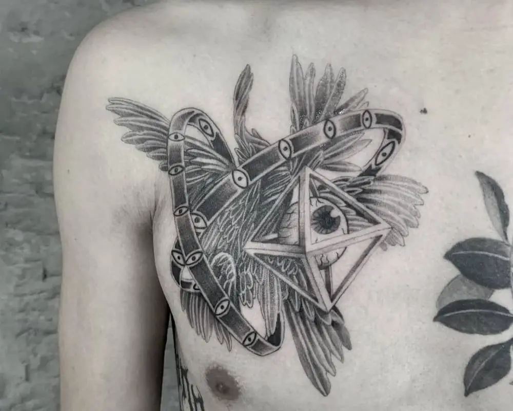 Tattoo in the form of wings and rings with eyes as well as an eye in a rhombus
