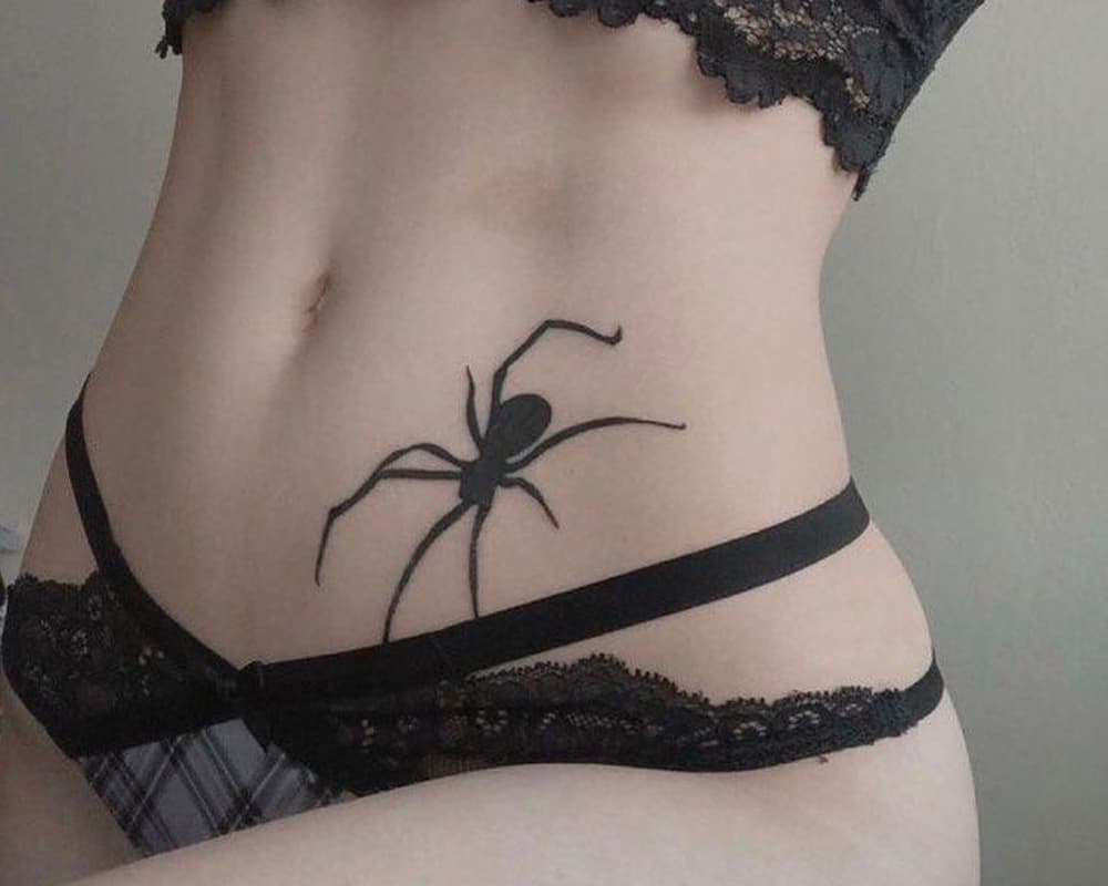 Tattoo in the shape of a large black spider on the stomach