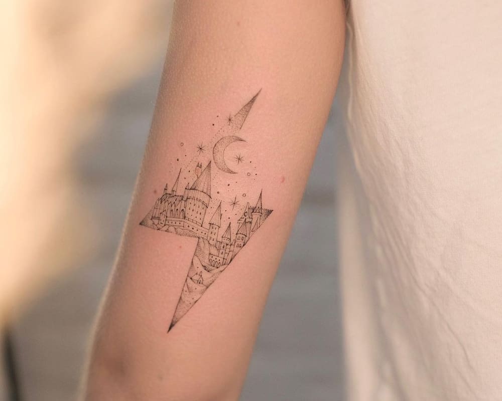 Tattoo of Hogwarts with stars and the moon in a lightning bolt